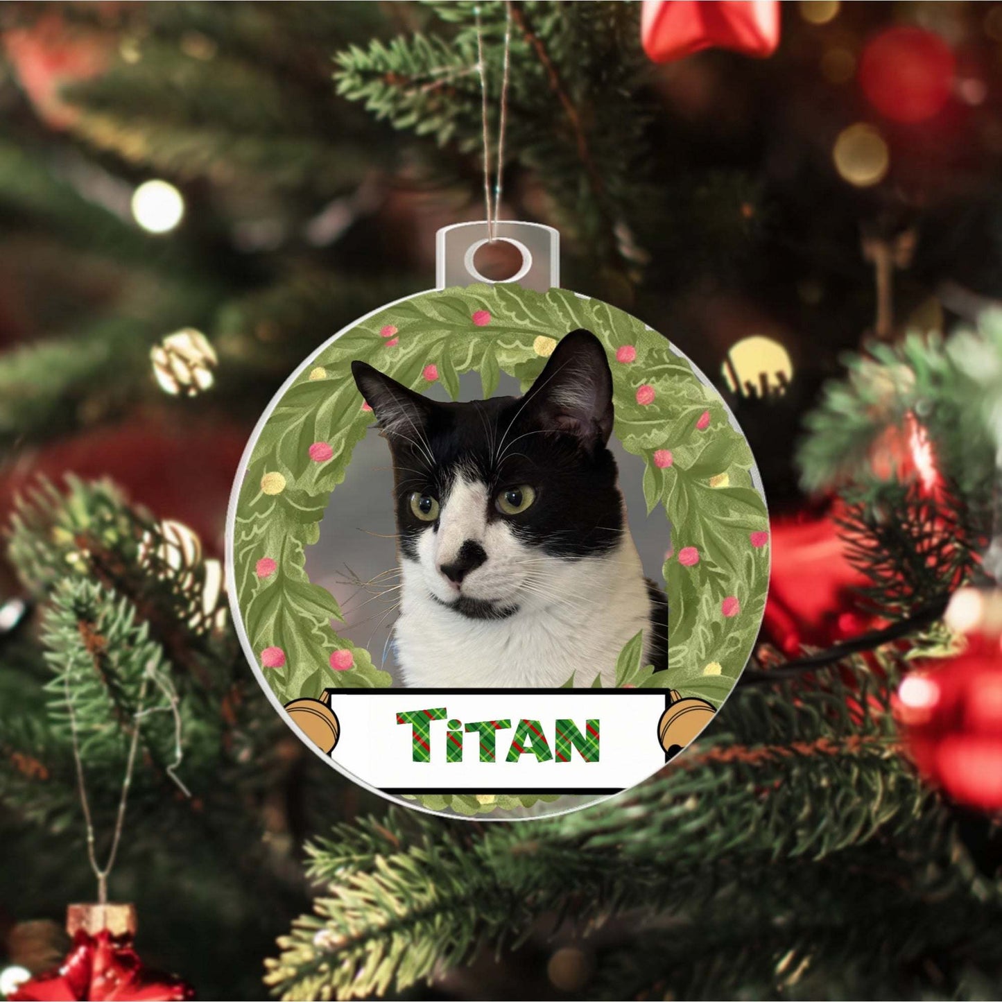 Custom Pet Acrylic Ornament featuring black and white cat named Titan with festive wreath design hanging on Christmas tree