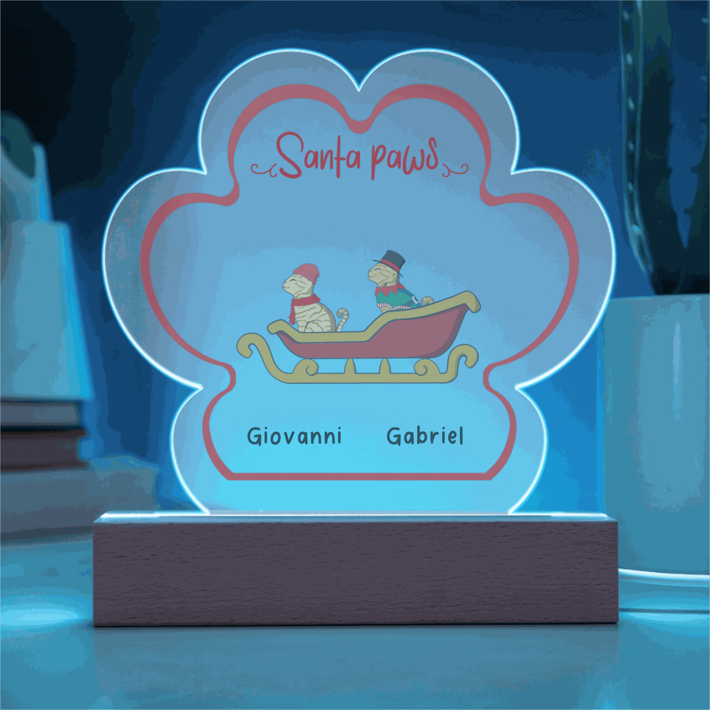 LED-lit acrylic paw print Christmas plaque with custom pet names and festive design on wooden base