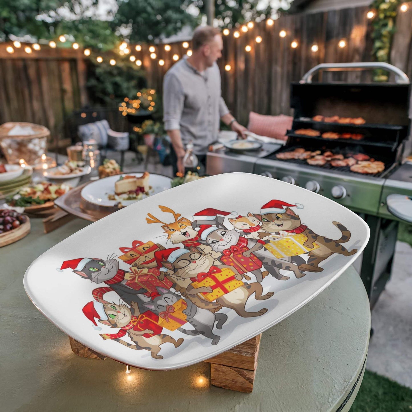 Christmas platter with festive cats carrying gifts on an outdoor table next to a grill