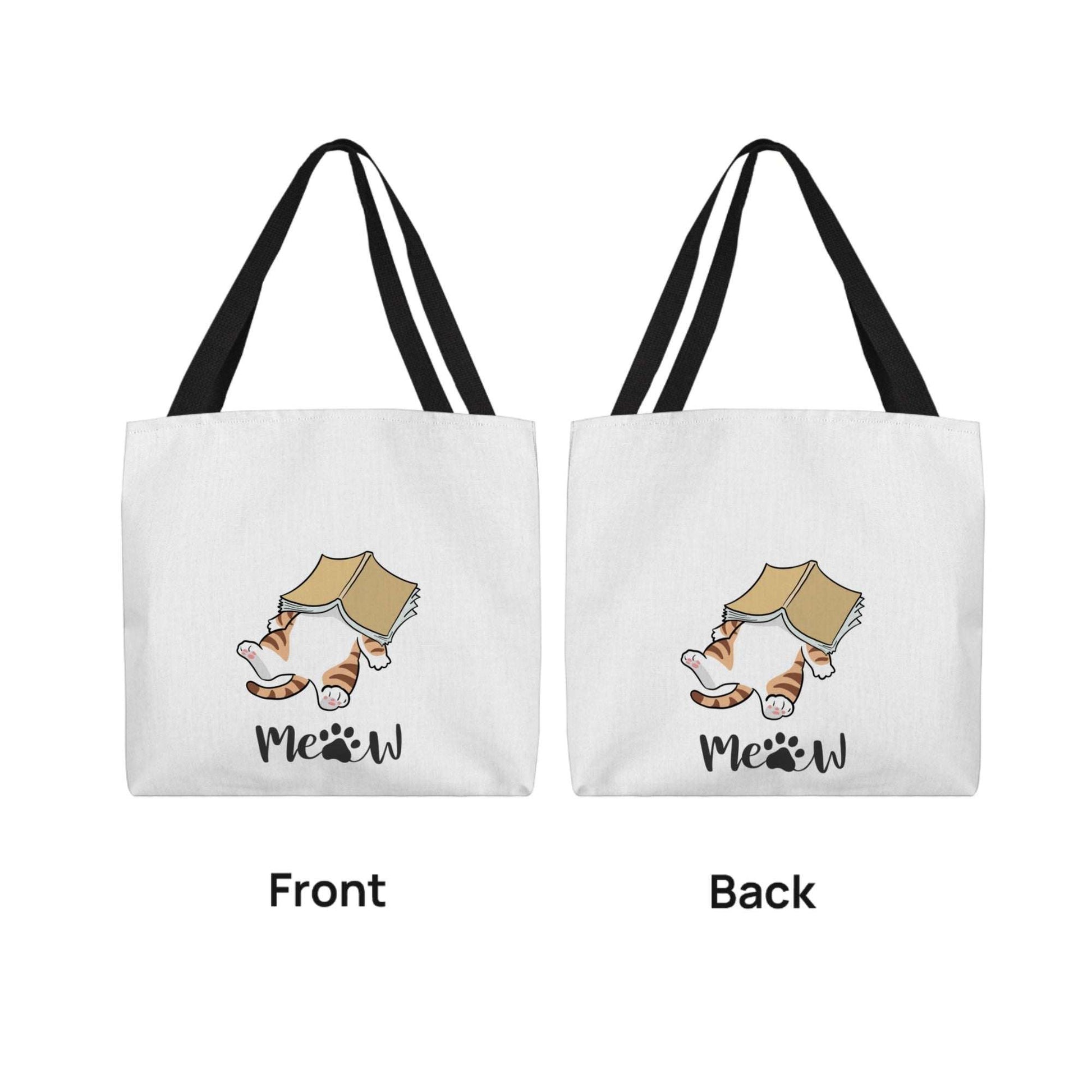 Cat's Meow Classic Tote Bag with cat reading a book and customizable name options, white fabric with black handles.