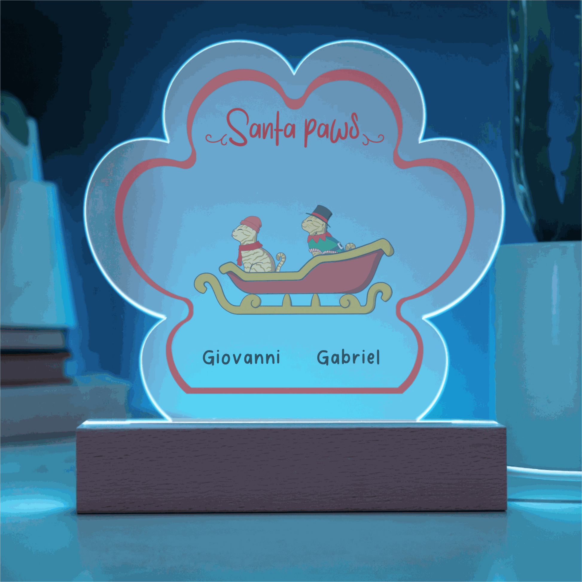 LED-lit acrylic paw print Christmas plaque with custom pet names and festive design on wooden base