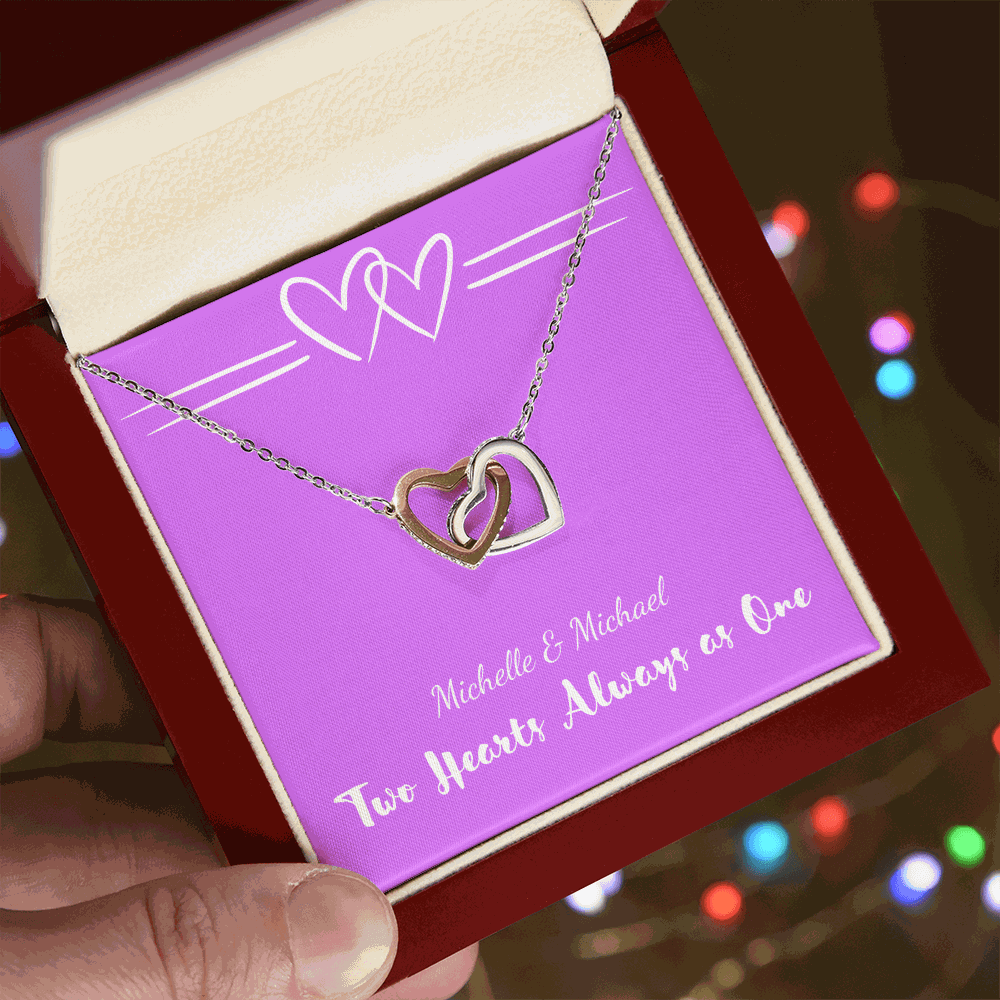 Interlocking Hearts necklace with two silver heart pendants in a red gift box