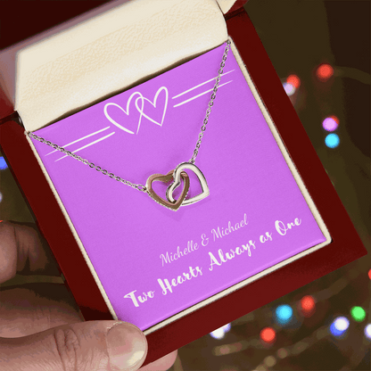 Interlocking Hearts necklace with two silver heart pendants in a red gift box