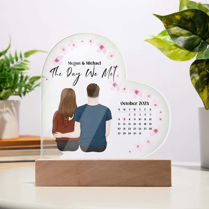 Personalized acrylic heart plaque with calendar and couple illustration commemorating The Day We Met, elegant keepsake on wooden base