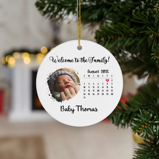 Custom birth announcement ornament with baby's photo, welcome message, and birth date calendar hanging on Christmas tree