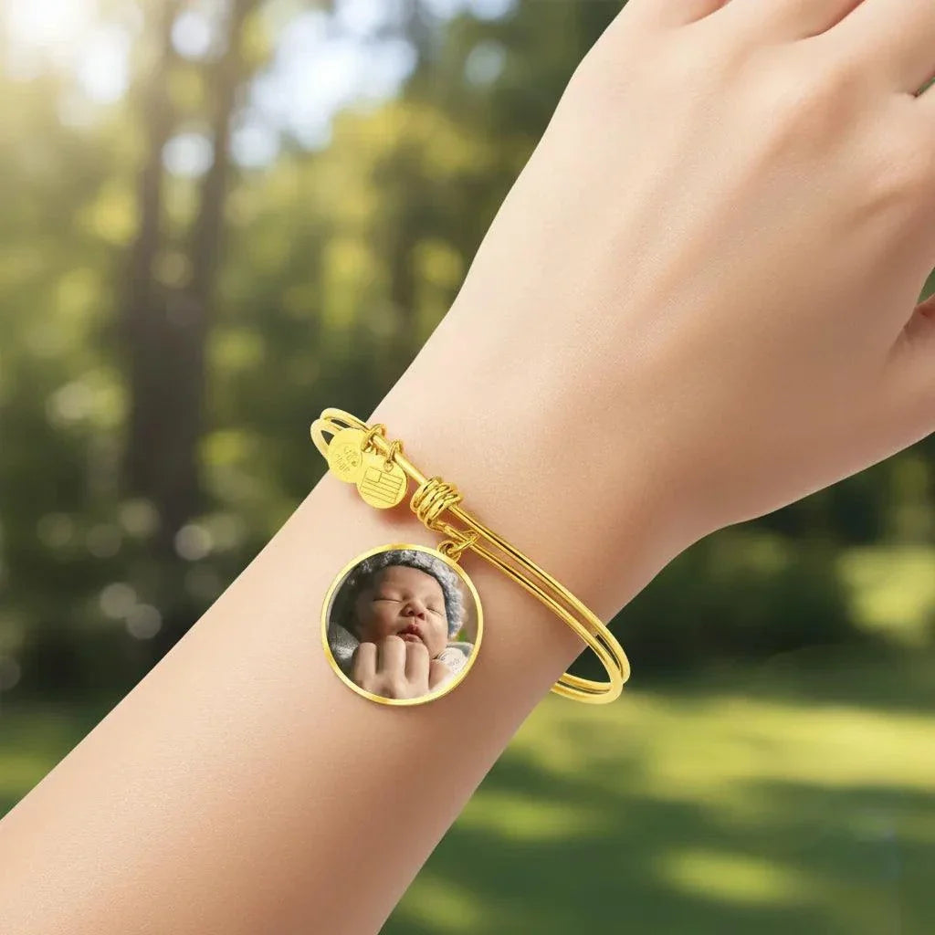 Circle Photo Bangle Bracelet in gold with customizable photo insert worn on wrist outdoors