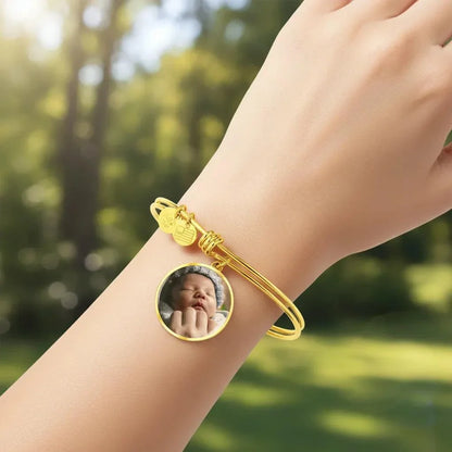 Circle Photo Bangle Bracelet in gold with customizable photo insert worn on wrist outdoors