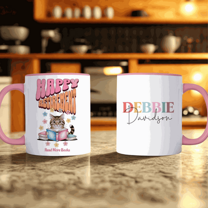 Happy Retirement Mug with pink handle featuring a cat reading books and personalized name "Debbie Davidson" on opposite side, ceramic gift for retirees, 11 oz mug
