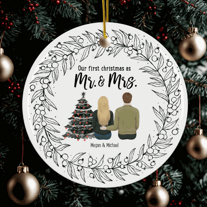 Customizable round Christmas ornament with "Our first christmas as Mr. & Mrs." text, couple illustration, and decorative wreath design hanging on a festive tree.